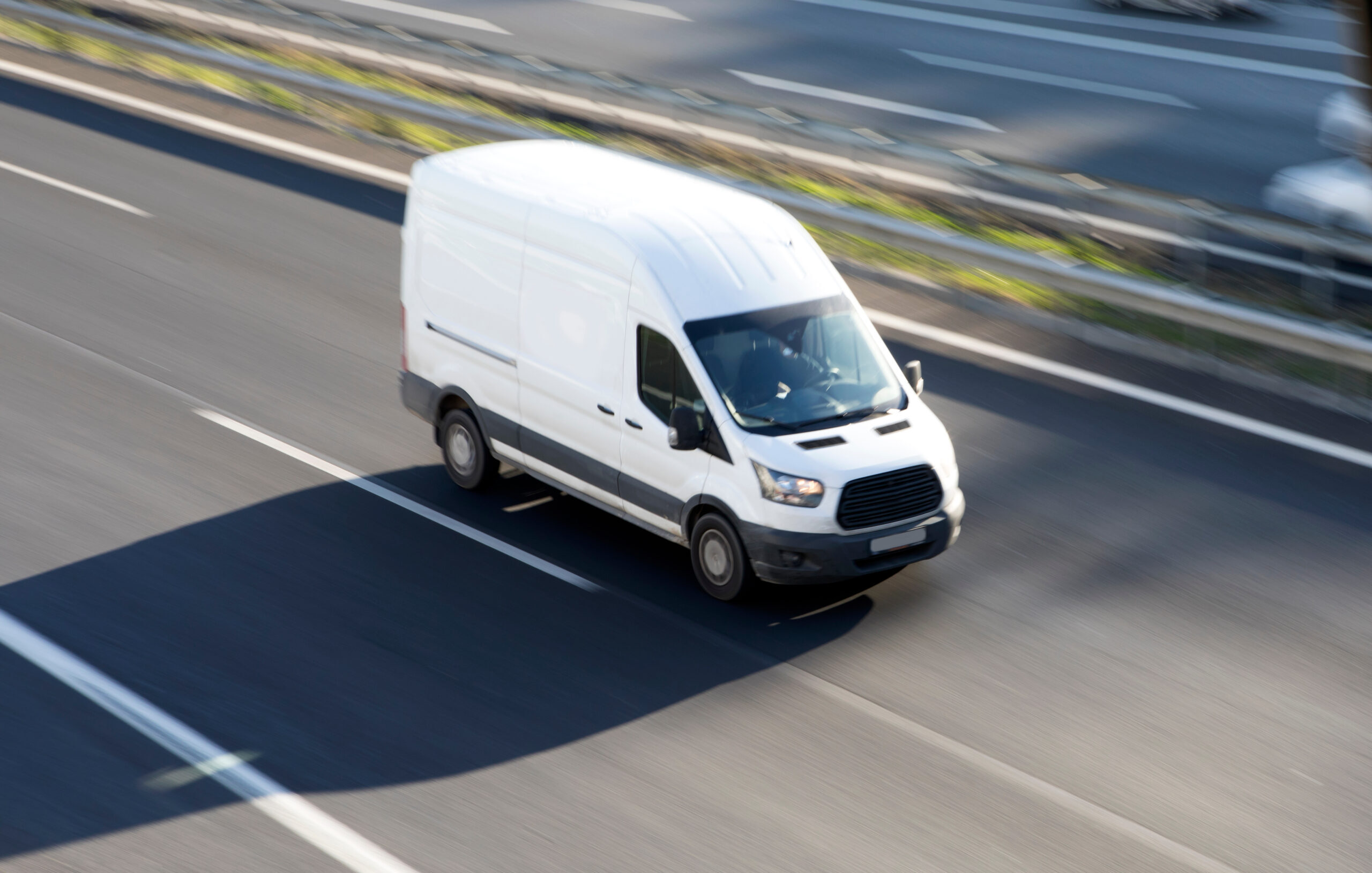 white van driving on highway